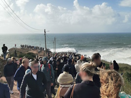 turistas a verem ondas gigantes na Nazaré na encosta